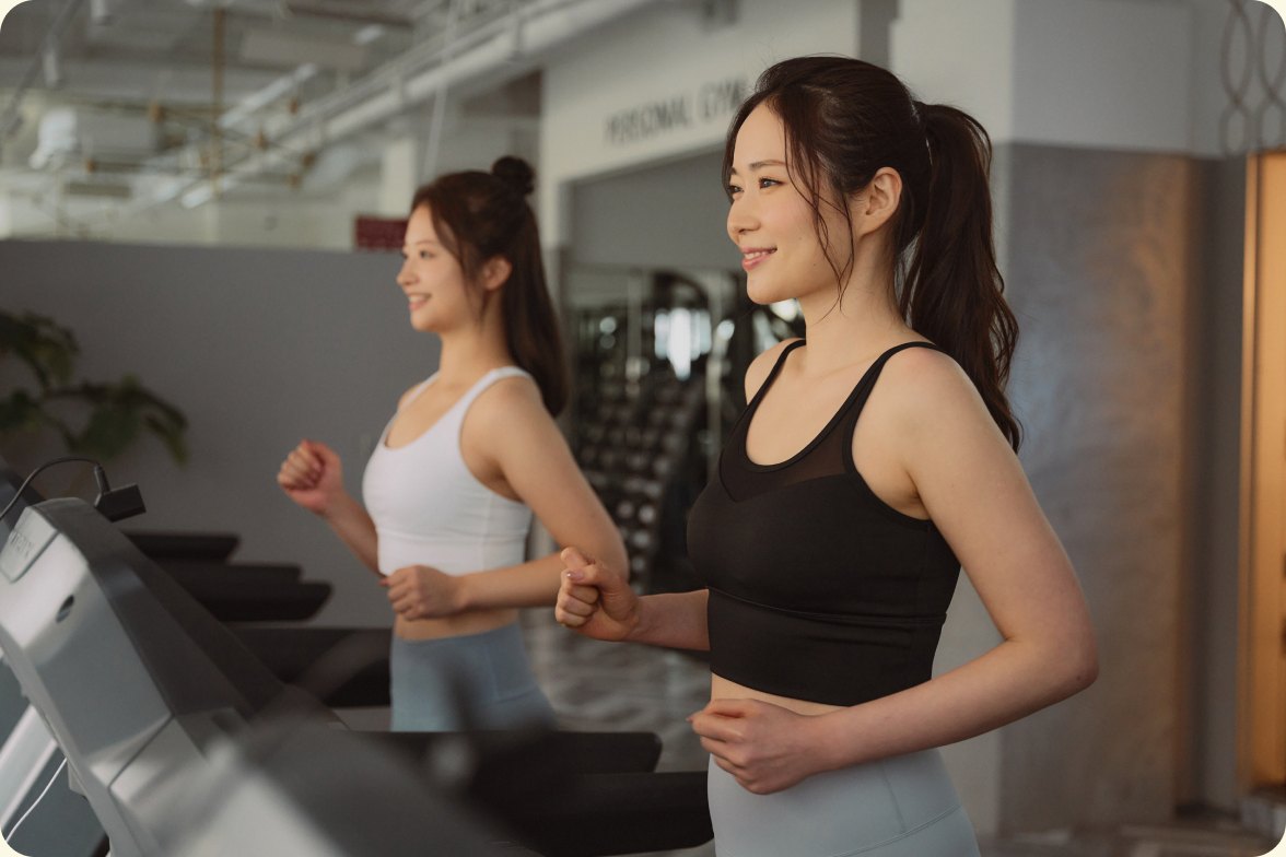 ジムのマシンでランニングをする二人の女性