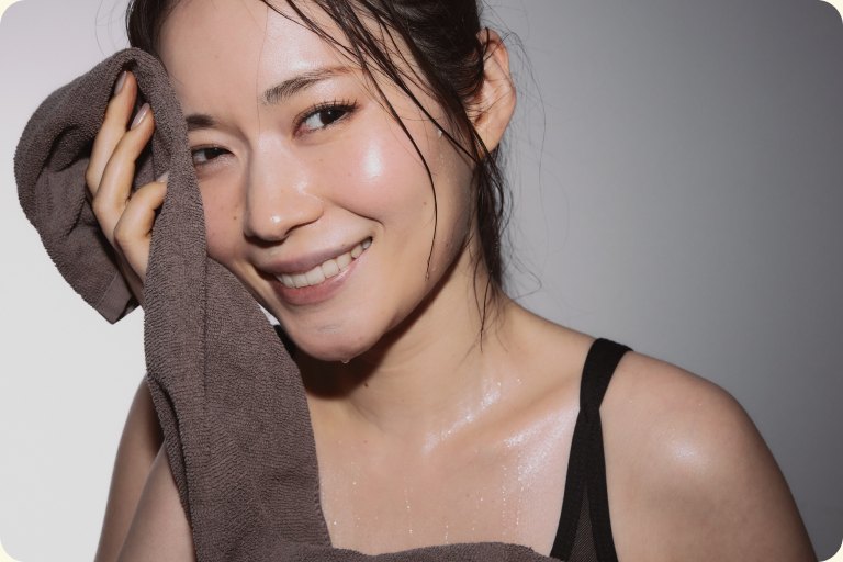 レッスン後にタオルを持って微笑む女性
