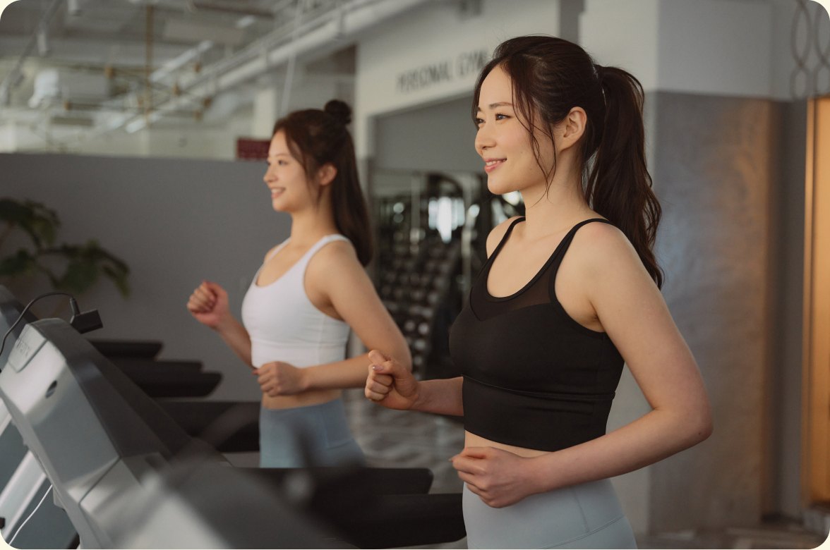 ジムのマシンでランニングをする二人の女性